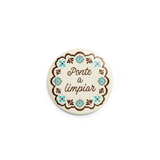 Mockup of pin back button with design that says Ponte a Limpiar (Get to Cleaning)